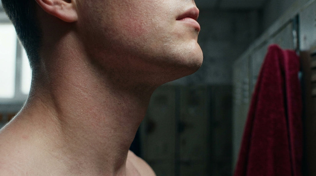 Close-up of smooth post-shave jaw and neck skin with a light cosmetic mist applied