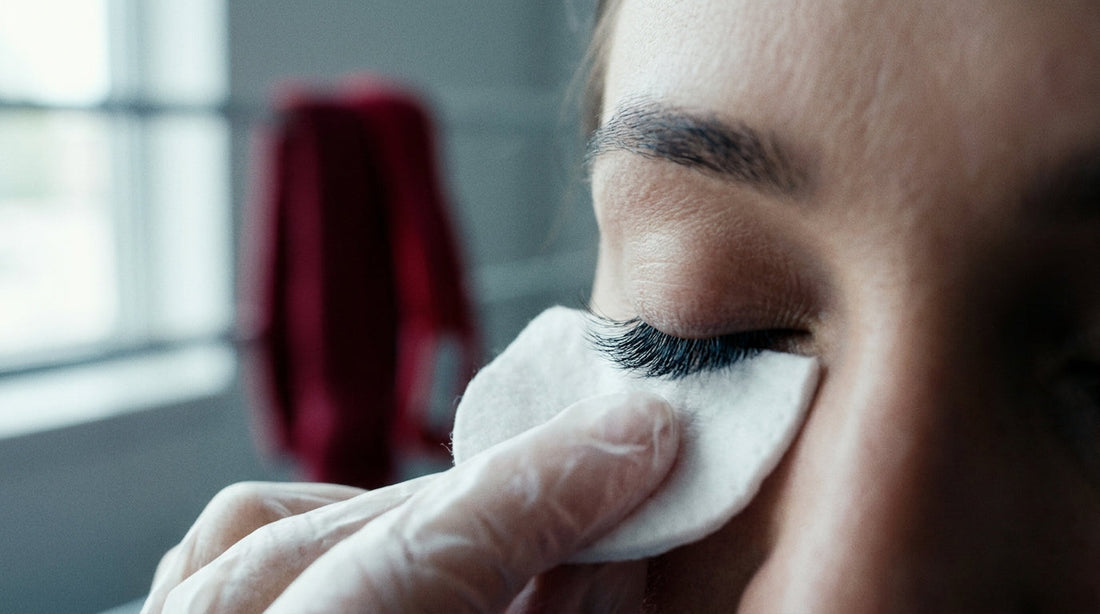 Macro close-up of lash extensions being cleaned along the lash line with a lint-free pad