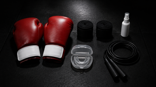 Boxing equipment for beginners: red boxing gloves, hand wraps, gum shield, skipping rope and hygiene spray