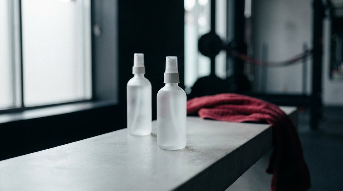 Two frosted facial spray bottles side by side comparing hypochlorous acid mist and setting mist