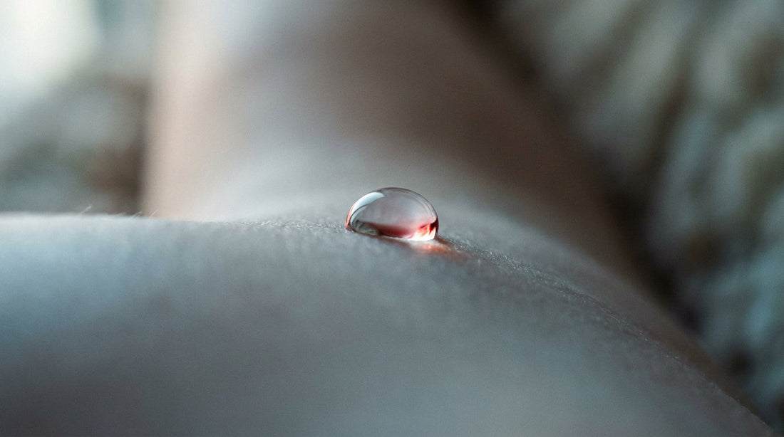 Macro of a single water droplet resting on calm sensitive skin illustrating skin barrier compatibility